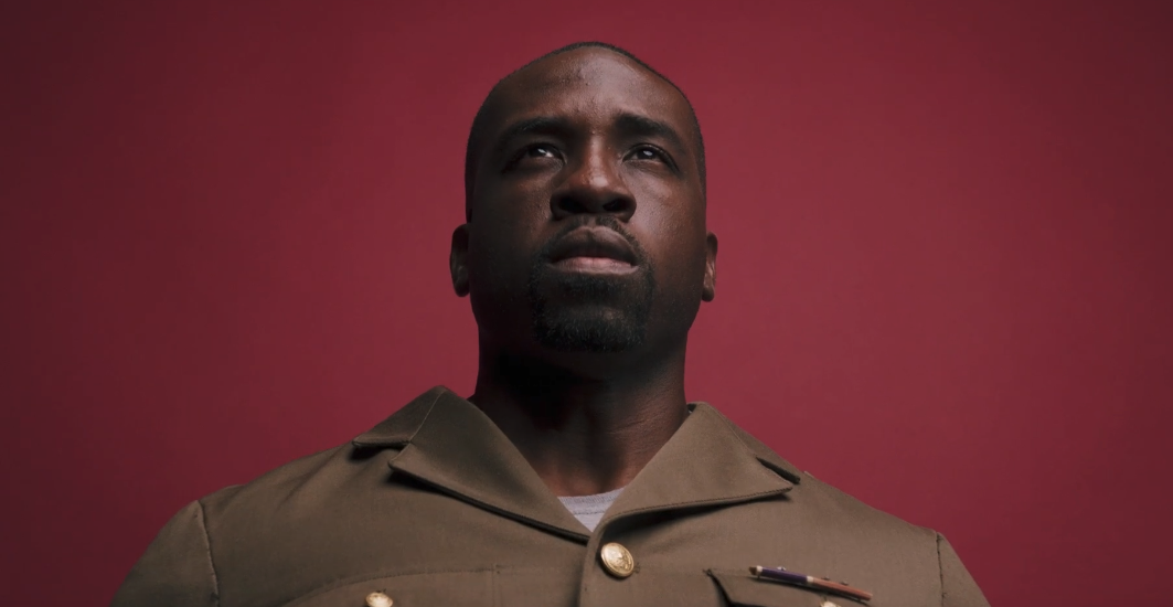 A person in military uniform looking up.